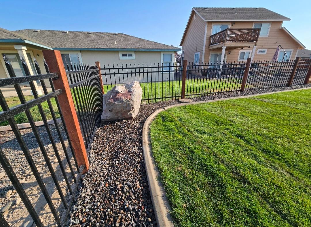 Black iron fence with gravel landscape