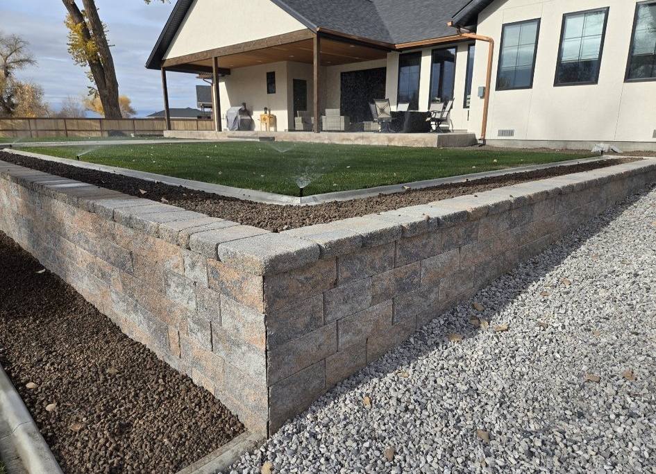 Stone block retaining wall with turf